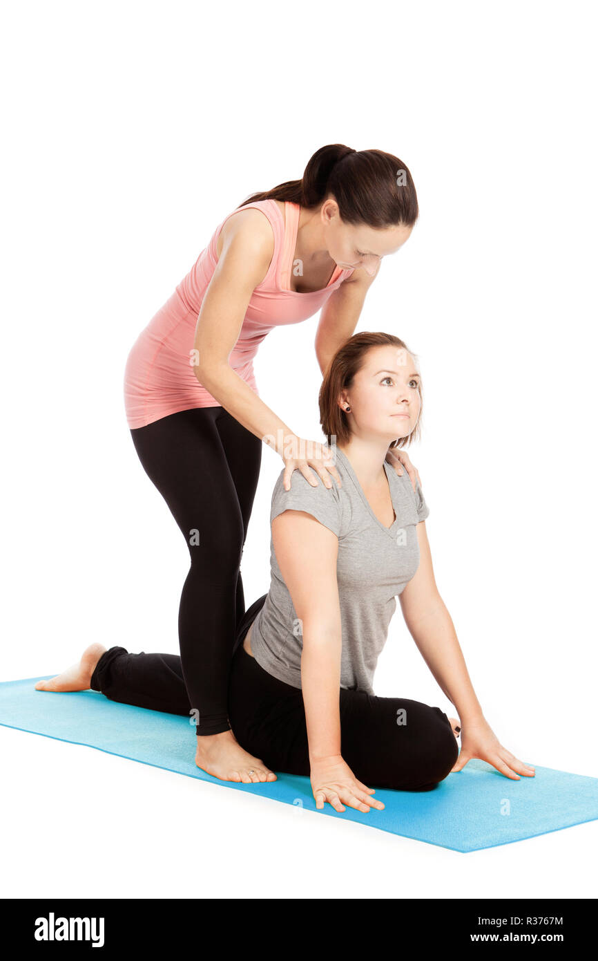 Insegnante di yoga offre assistenza nella formazione,eka pada kapotasana Foto Stock