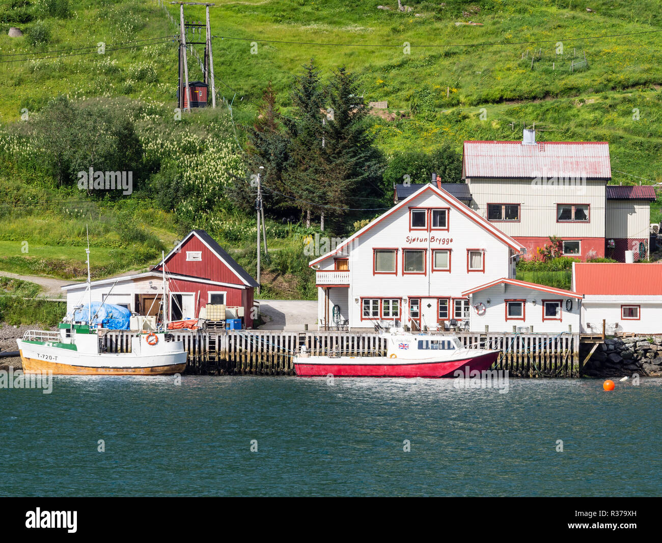 Casa, barca presso il molo, Katfjord, isola Kvalöya ad ovest di Tromsö, Nordland. Foto Stock