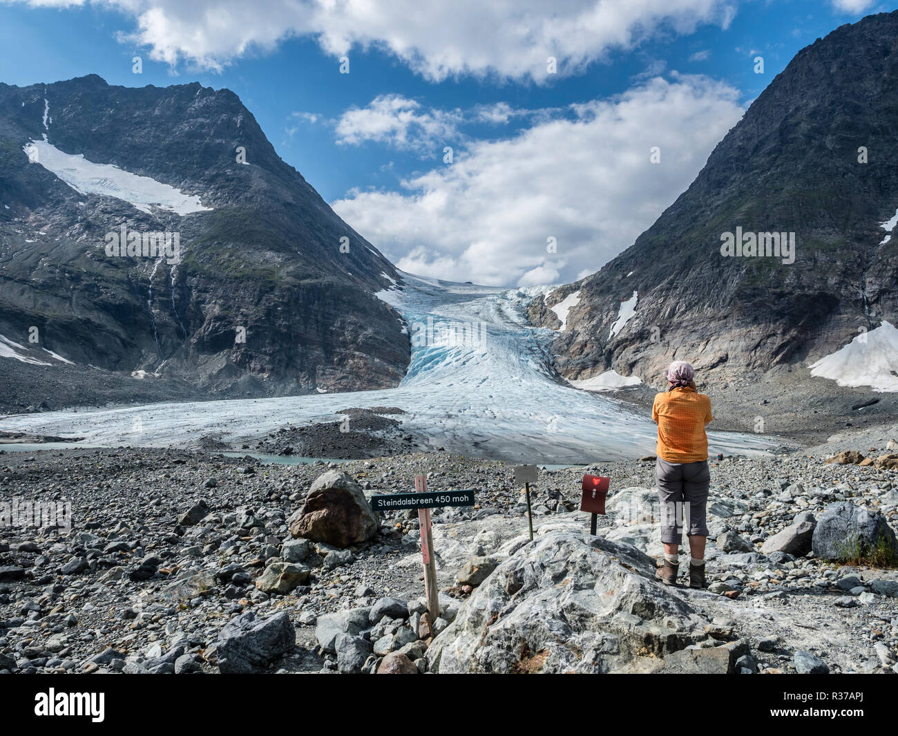 La donna a scattare foto, il ghiacciaio Steindalsbreen, lingua del ghiacciaio, segnaletica e 'trimkassa' alla fine della valle, Steindalen Lyngen Alpi, a sud di Lyngseidet Foto Stock