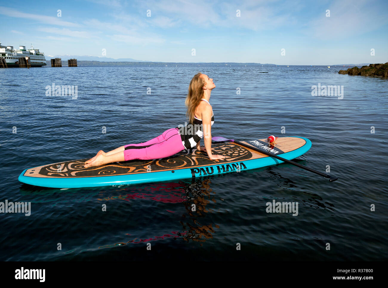 PE00286-00...WASHINGTON - Carly Hayden facendo paddle board yoga nella Puget Soundat a Brackett's Landing Nord, Edmonds. (MR #H13) Foto Stock