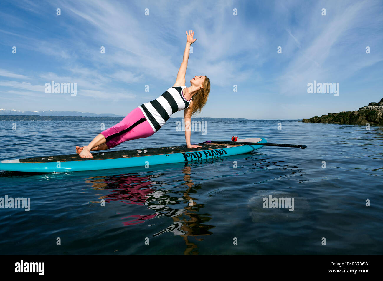 PE00294-00...WASHINGTON - Carly Hayden facendo paddle board yoga nella Puget Sound a Brackett's Landing Nord, Edmonds. (MR #H13) Foto Stock