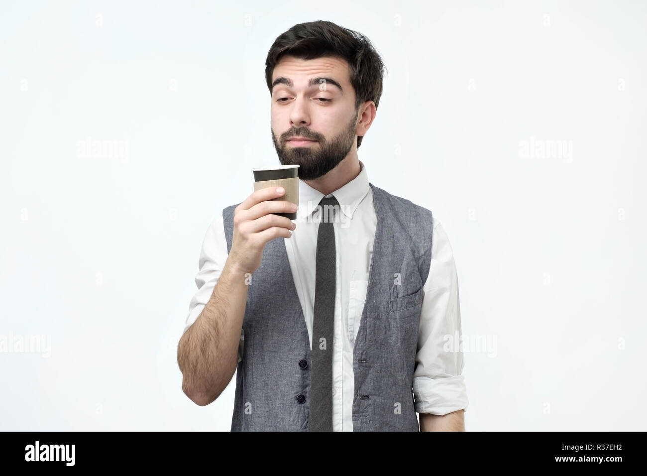 Assonnato guy tenendo una tazza di caffè. Foto Stock