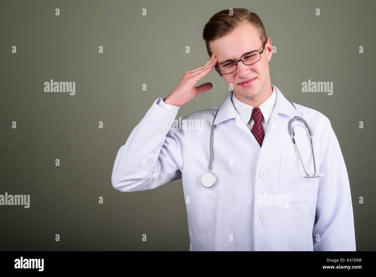 Giovane uomo bello medico contro sfondo colorato Foto Stock