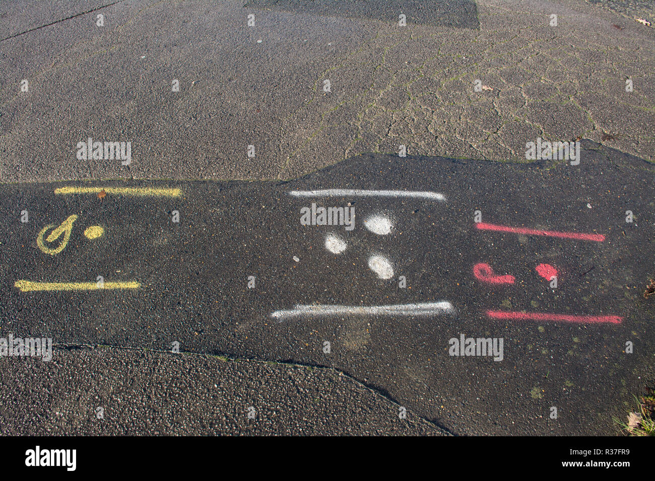 Verniciato a spruzzo squiggles marcature sulla strada fatta dagli appaltatori che indicano il posizionamento di acqua, di gas e di energia elettrica, tubi, cavi Foto Stock