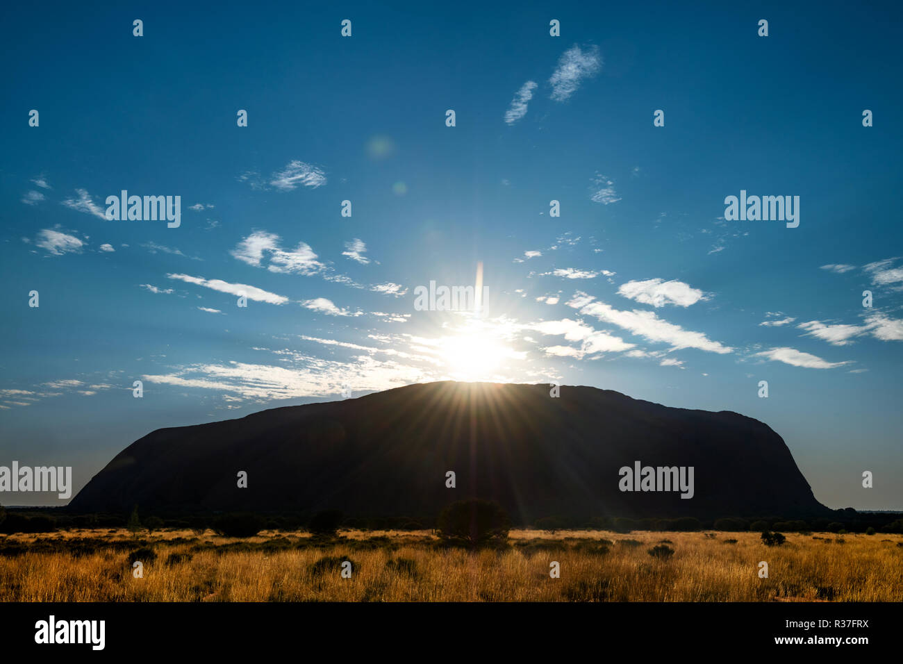 Il sorgere del sole oltre il famoso Uluru. Foto Stock