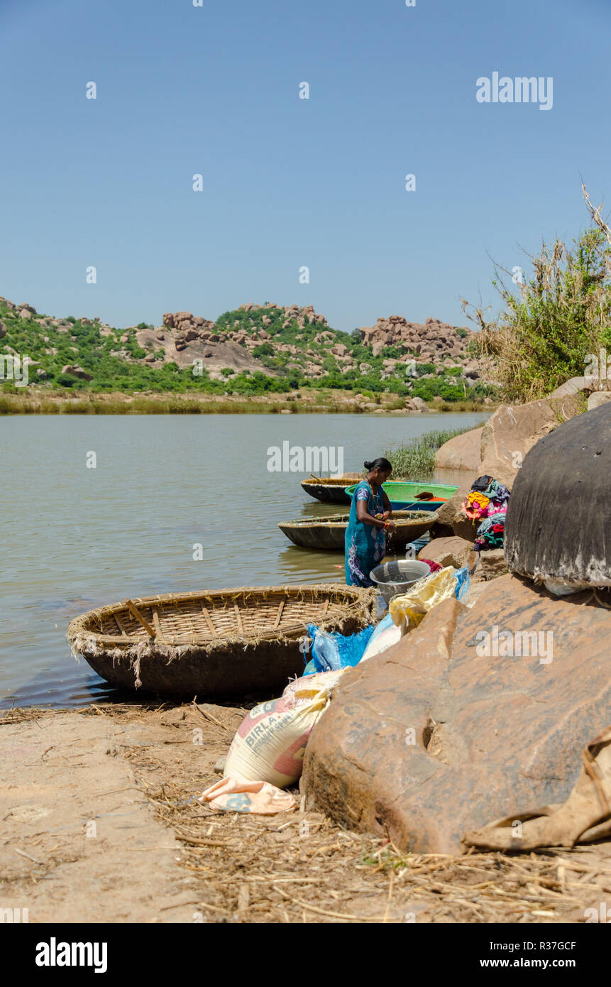 Una donna locale a lavare i panni nel fiume Tungabhadra a Talvar Gatta, Anegundi, Karnataka, India Foto Stock