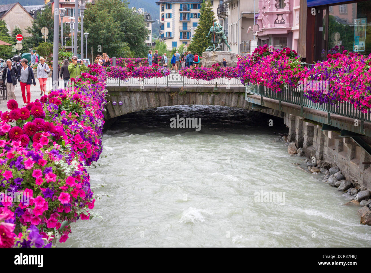 Flower cesti riempiti con rosa e viola nelle petunie sui lati del fiume Arve nel centro di Chamonix nelle Alpi francesi. Foto Stock