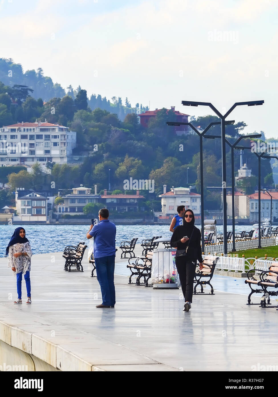 Istanbul, Turchia - 21 settembre - 2018. Le persone sono passeggiate e sport sul lungomare. Donna musulmana in una tuta nera è a piedi, un padre Foto Stock