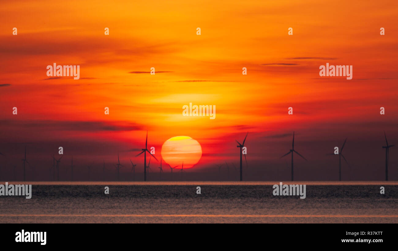 Sulle turbine eoliche offshore a sunrise in Colwyn Bay sulla costa settentrionale del Galles Foto Stock