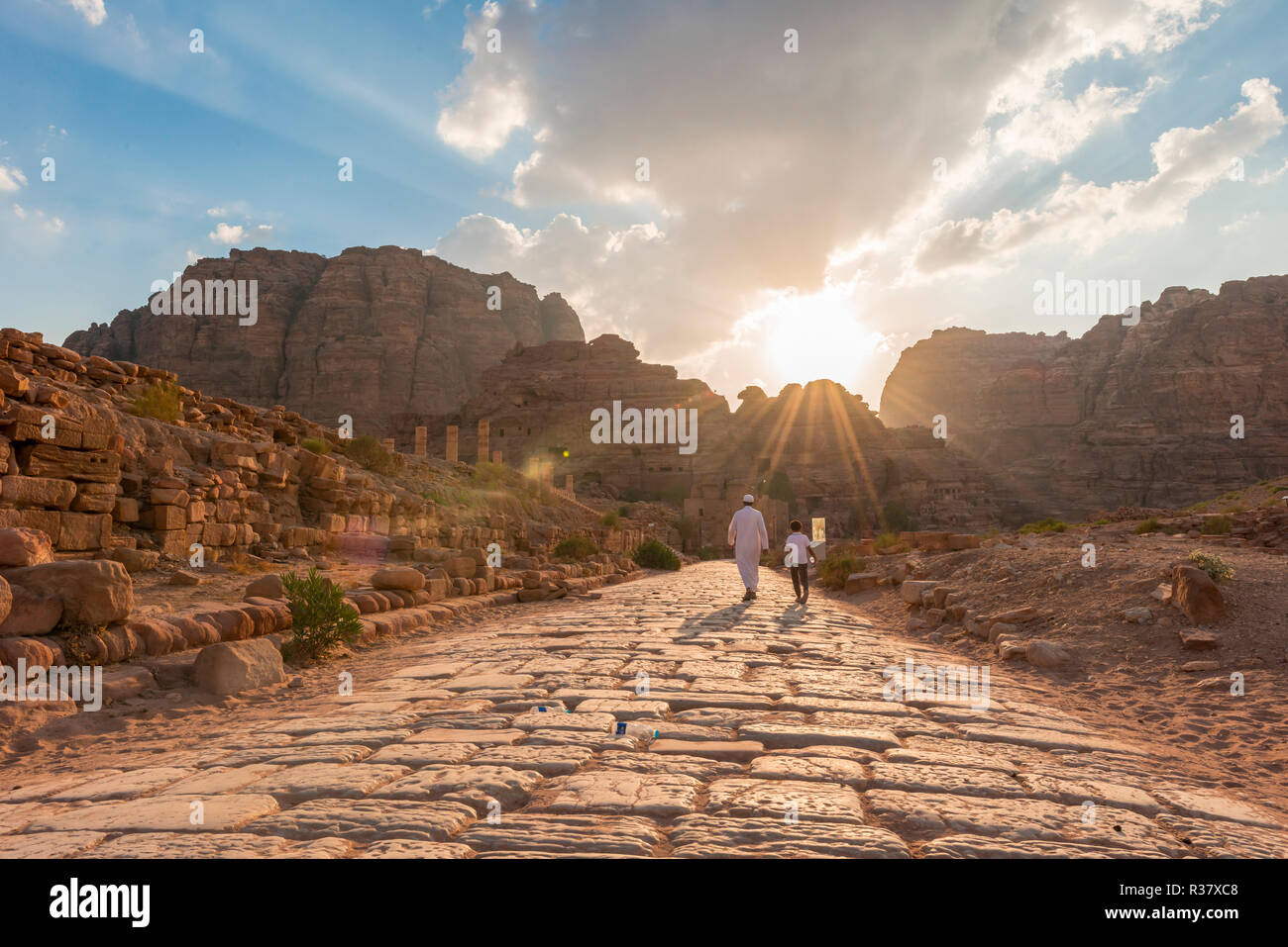 Due locali a piedi sulla vecchia strada romana accanto alle rovine di Petra, Nabataean città di Petra, vicino a Wadi Musa, Giordania Foto Stock