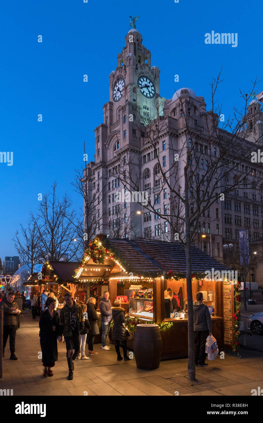 Mercatino di Natale si spegne al Natale Festival di ghiaccio in fiera con il Liver Building dietro, Pier Head, Liverpool, England, Regno Unito Foto Stock