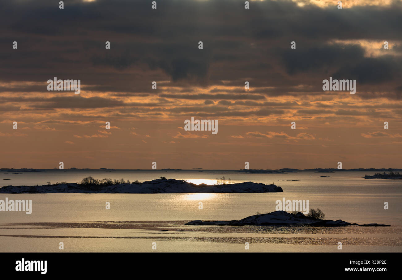 Il sole splende da nuvole dietro, riflettendosi nel Mar Baltico Foto Stock