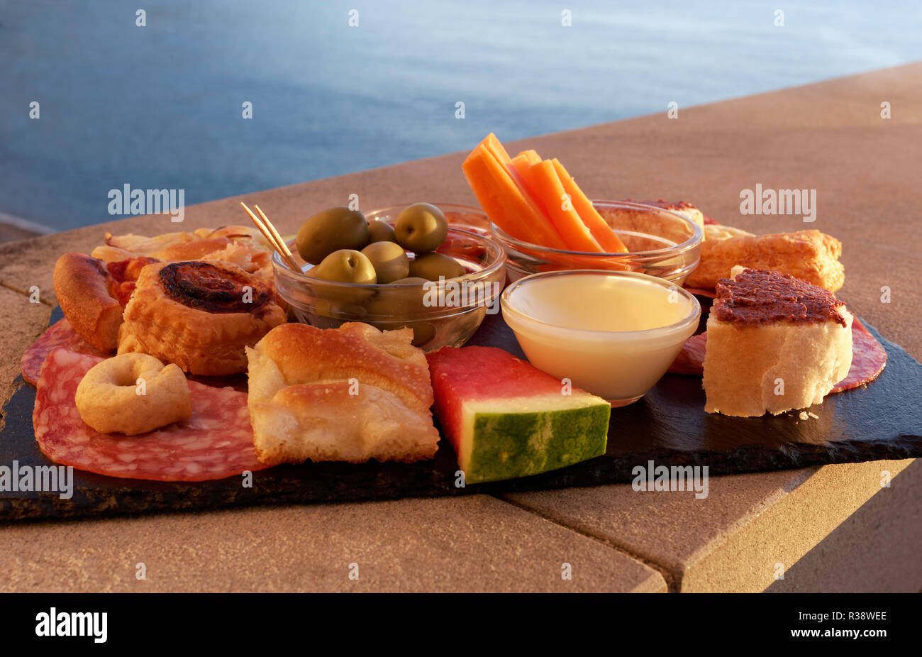 Piastra di snack con focaccia, salsiccia, dip e olive, Camogli, provincia di Genova, Riviera di Levante, Liguria, Italia Foto Stock