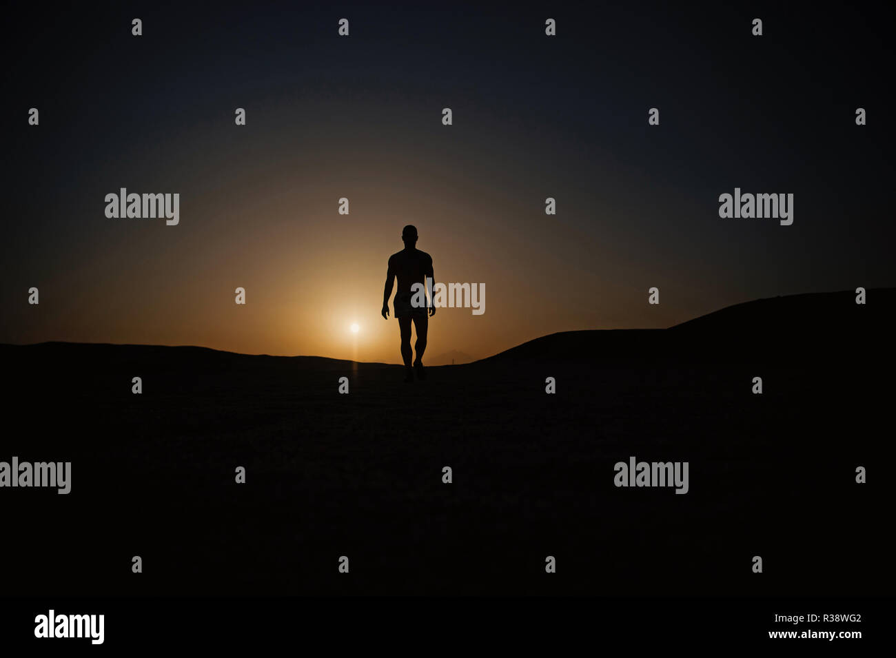 Silhouette uomo. silhouette di un uomo a piedi sul tramonto Cielo fiery background in montagna, sport e ricreazione, di futuro e di successo, la gente e la natura, velocità e stile di vita sano Foto Stock