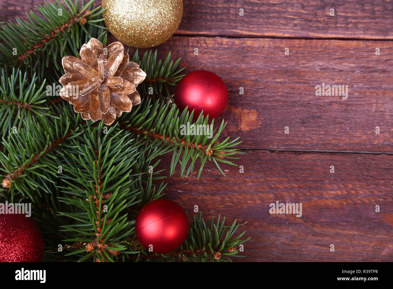 Natale o Capodanno background: pelliccia-tree, rami, vetro colorato sfere , decorazione e coni su uno sfondo di legno Foto Stock