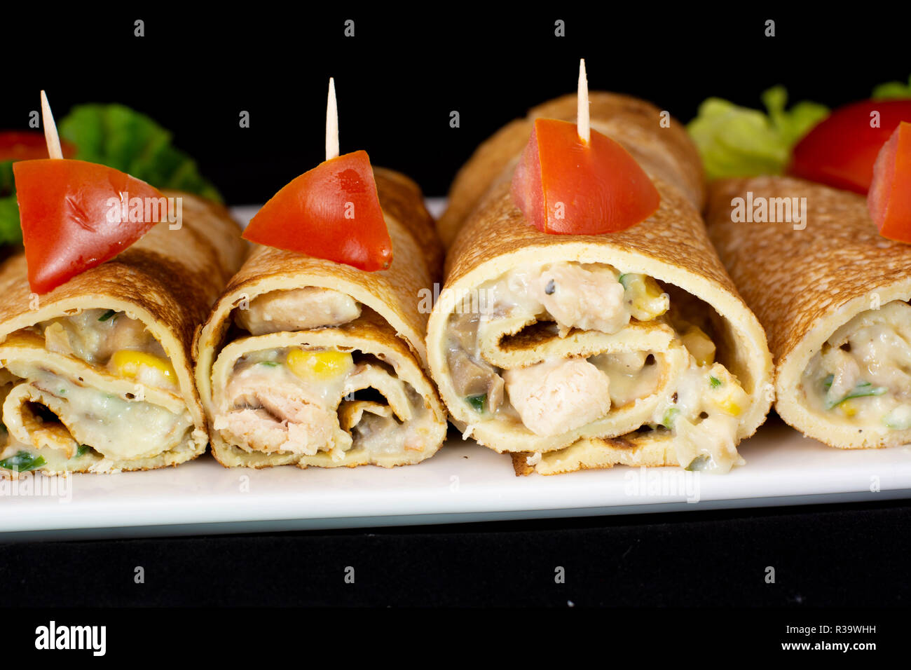 Pancake di pollo con insalata all'interno isolato con sfondo nero Foto Stock