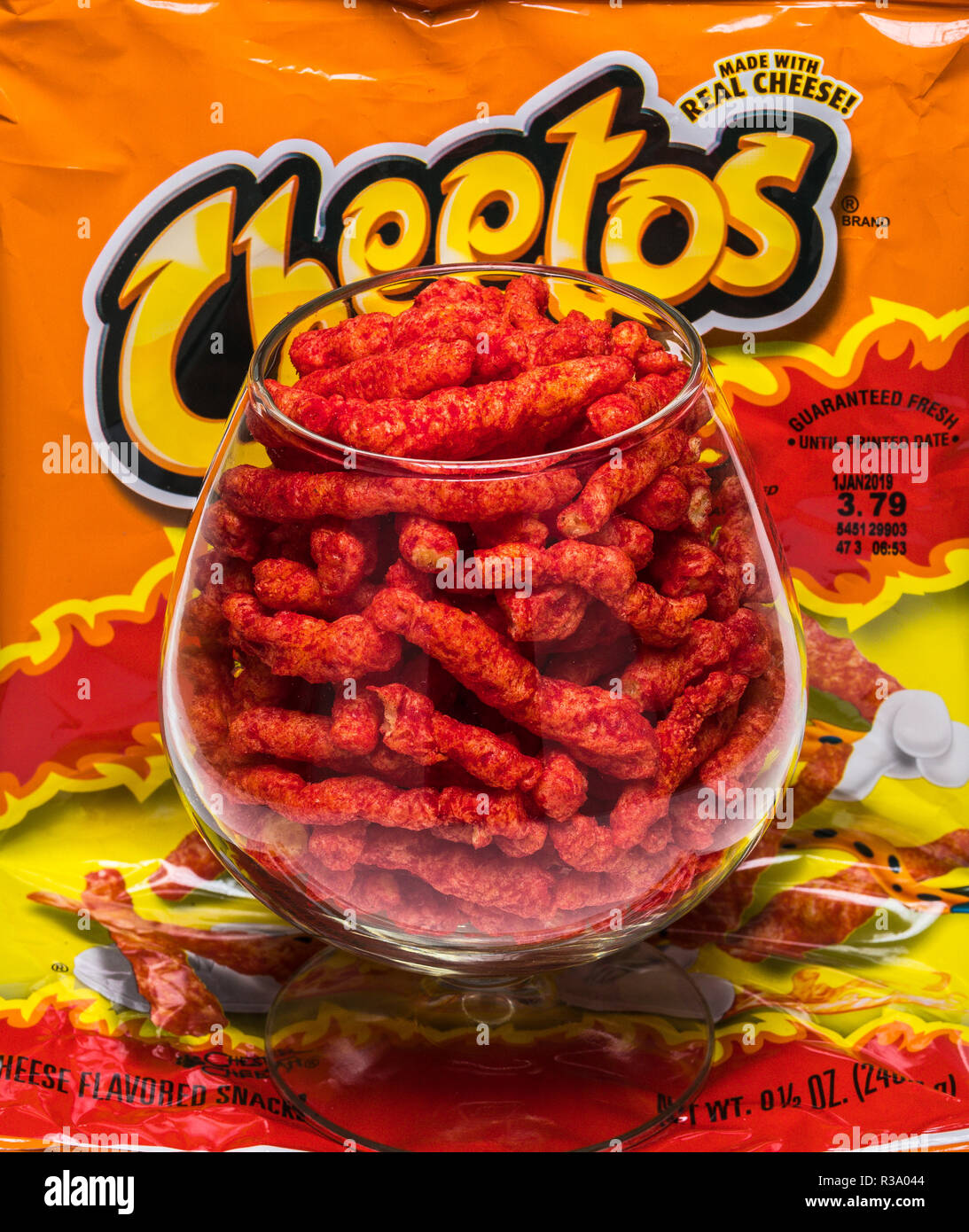Flamin' hot cheetos nel bicchiere di brandy con sacco Foto Stock