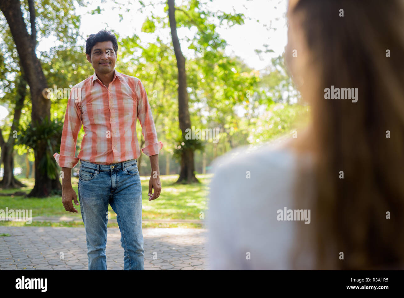 Felice Indian uomo sorridente e in piedi mentre guardando bella Foto Stock