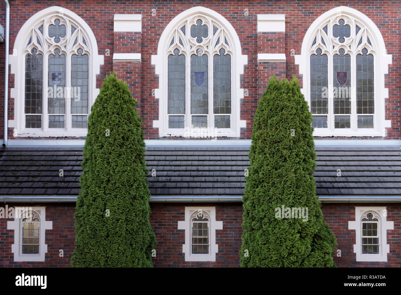 Stile neo-gotico windows e la facciata in mattoni rossi di San Agostino parrocchia della chiesa cattolica a Kitsilano, Vancouver, BC, Canada Foto Stock