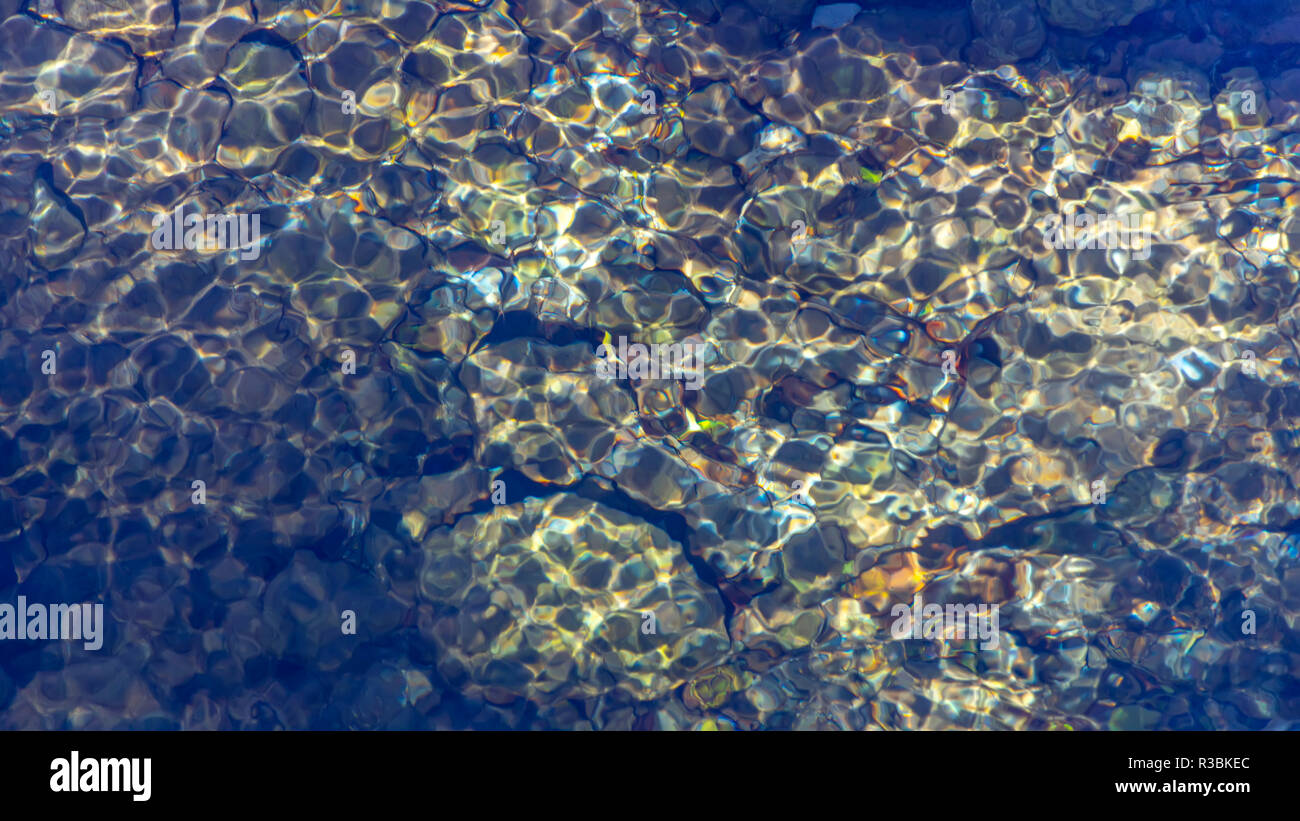 I riflessi del sole sull'acqua chiara superficie del flusso. Litochoro. La Grecia Foto Stock