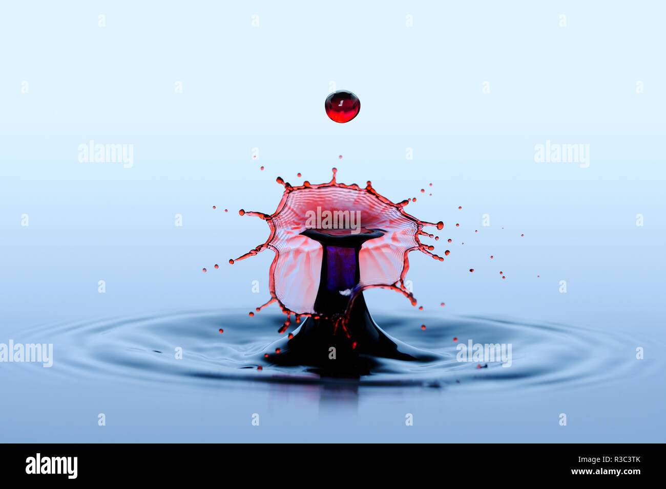 Spruzzi di acqua e splash. Effetto di collisione di due rosse cadere delle gocce di pioggia. Foto Stock