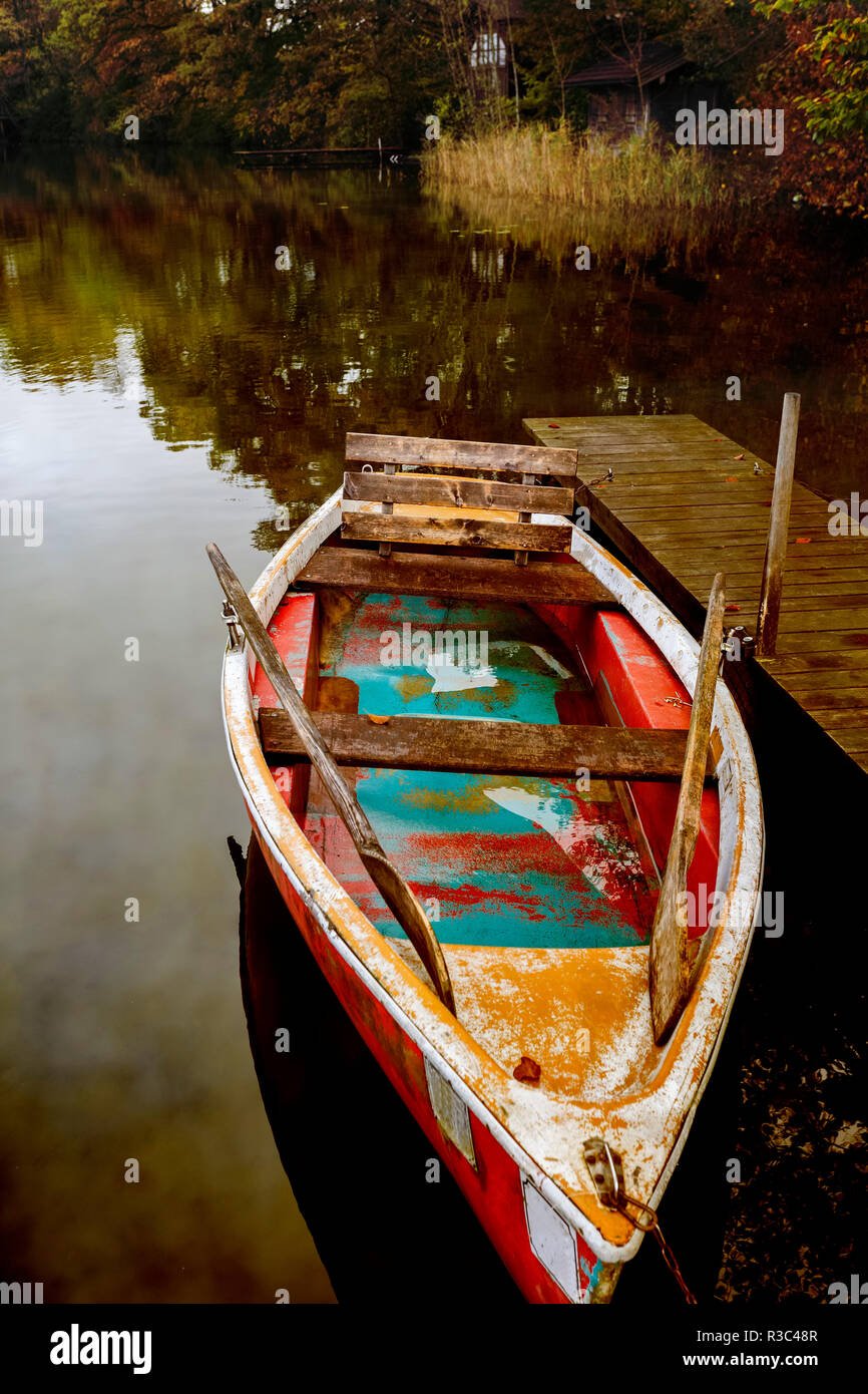 Vecchia barca a remi sulle sponde di un lago in autunno Foto Stock