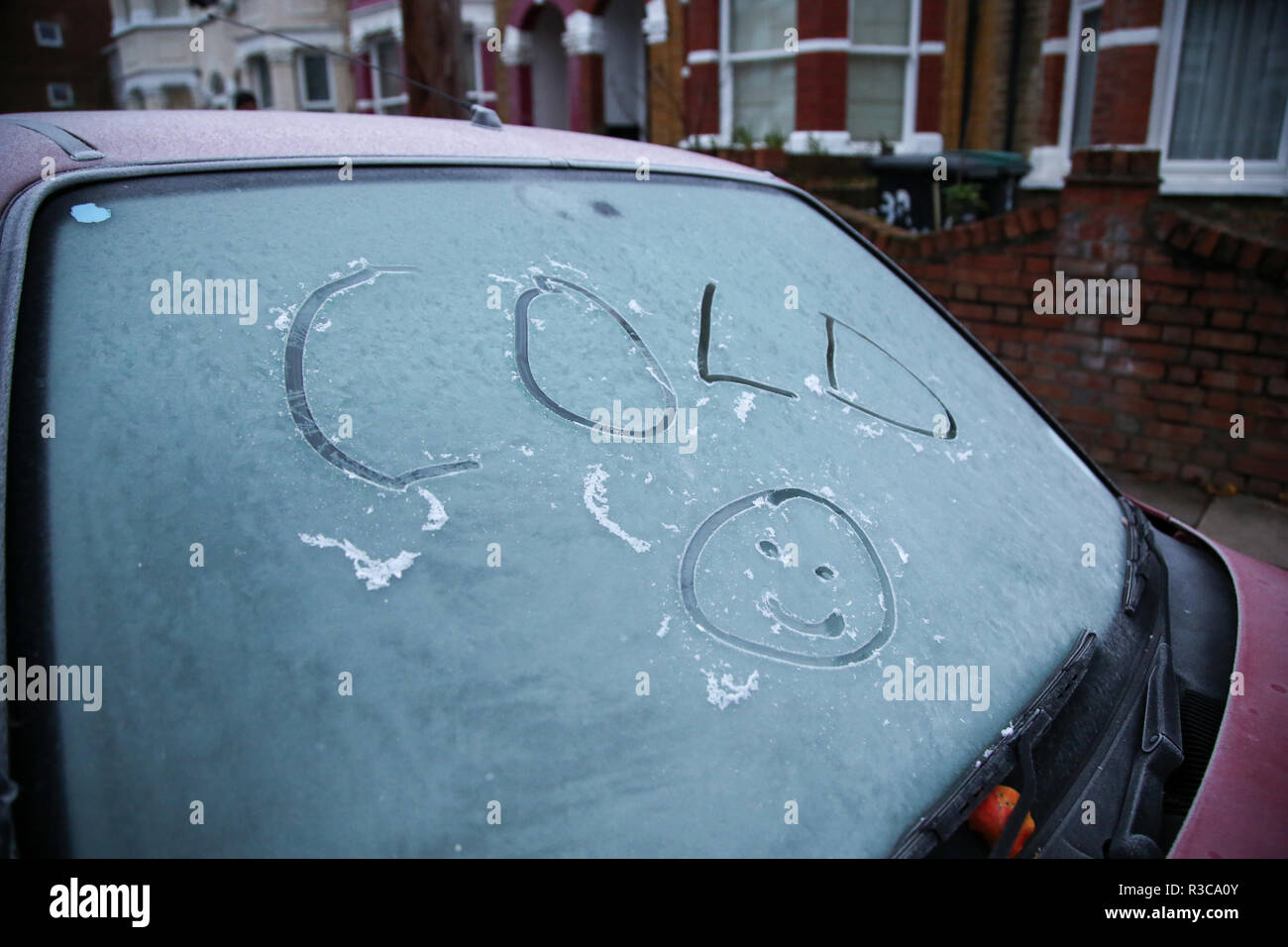 Freddo e un sorriso faccia, scritto su di un parabrezza di automobile coperto di brina è visto a Londra in seguito ad una fredda notte. Secondo il Met Office blizzards e temperature di congelamento sono impostati per arrivare in Gran Bretagna la prossima settimana come un vento artico spazza il paese. Le temperature sono suscettibili di immergersi a -10C e l'amara freeze - con gales dalla Siberia e neve pesante - è atteso per ultimo attraverso il Natale. Foto Stock