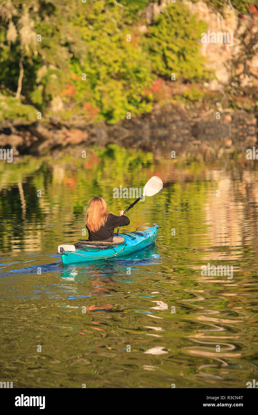 Kayakers in Clam Cove vicino al passaggio di doratura, Nord Isola di Vancouver, British Columbia, Canada Foto Stock