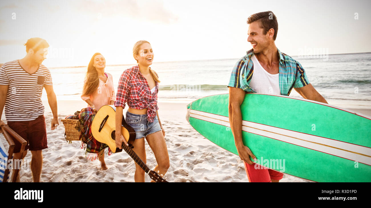 Gli amici che porta una tavola da surf e basket Foto Stock