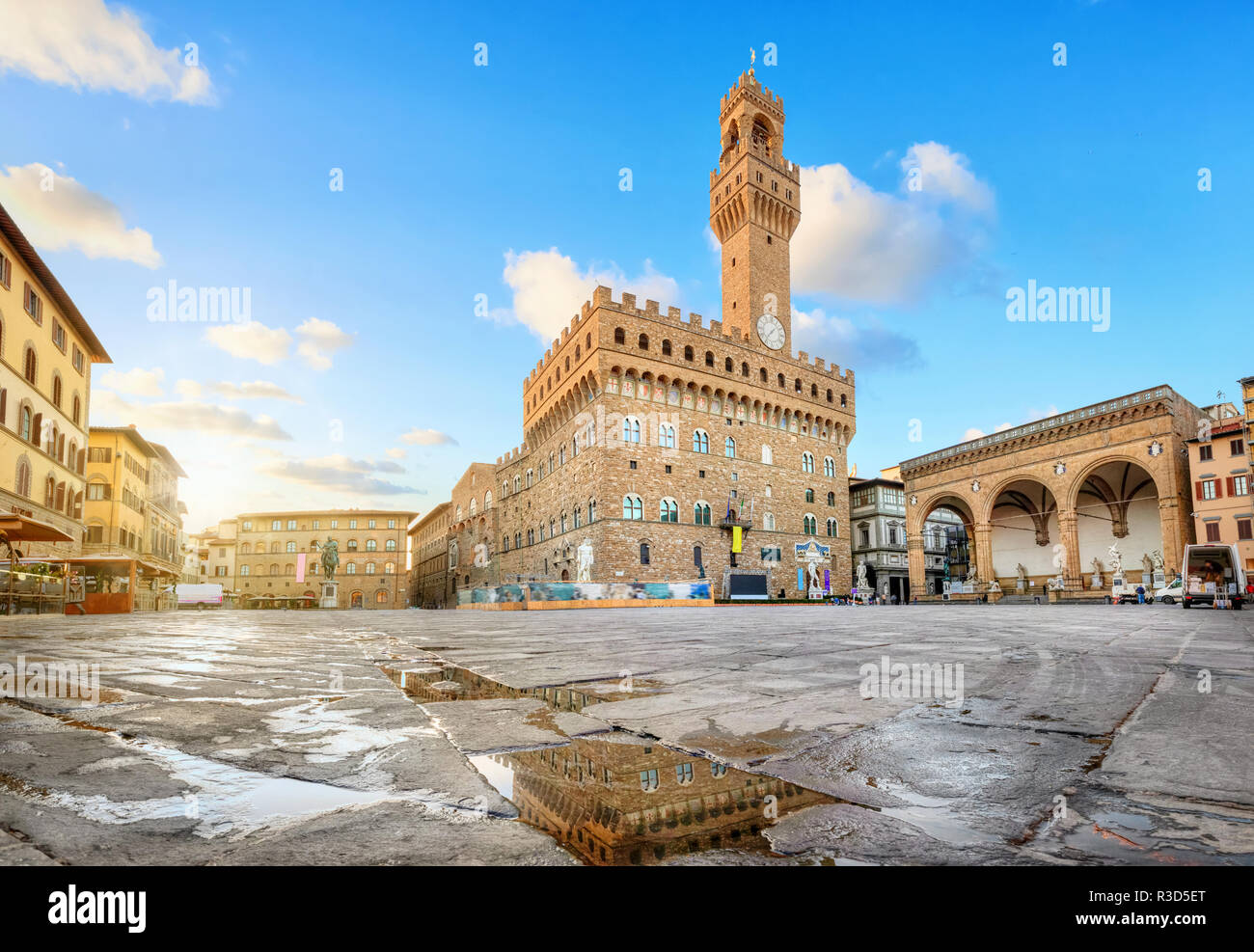 Firenze, Italia. Vista di Piazza della Signoria con il Palazzo Vecchio riflettendo in una pozza di sunrise Foto Stock