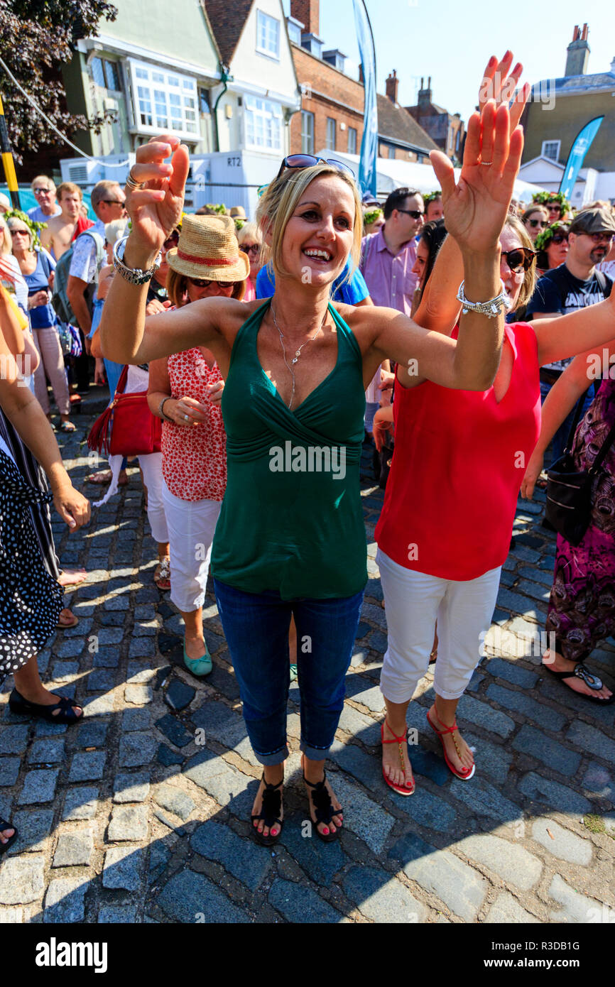 Faversham Hop Festival 2018, ventole guardando allentato cambiare banda sul palco. Donna matura nella parte anteriore del visualizzatore in verde in alto, tifo, bracci sollevati. Foto Stock