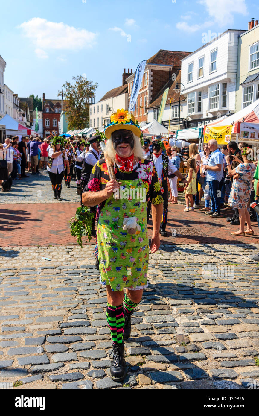 Faversham hop festival. Parade, Dead Horse e il Broomdashers Morris, con facce oscurati, camminando verso il telespettatore lungo la strada di piombo in un Morris stolto. Foto Stock