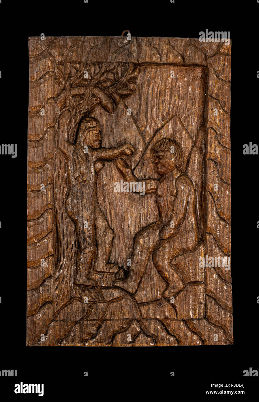 Ingenuo o folk intaglio del legno bassorilievo lapide che rappresenta il classico Adamo ed Eva oggetto. Isolato su nero. Foto Stock