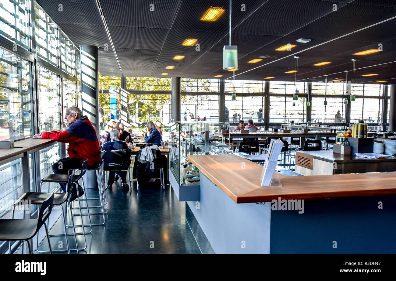 Godersi la bella qualità di streaming di luce attraverso le finestre mentre prendendo una pausa di prosecco in cafe al museo KKL di Lucerna, Svizzera. Foto Stock