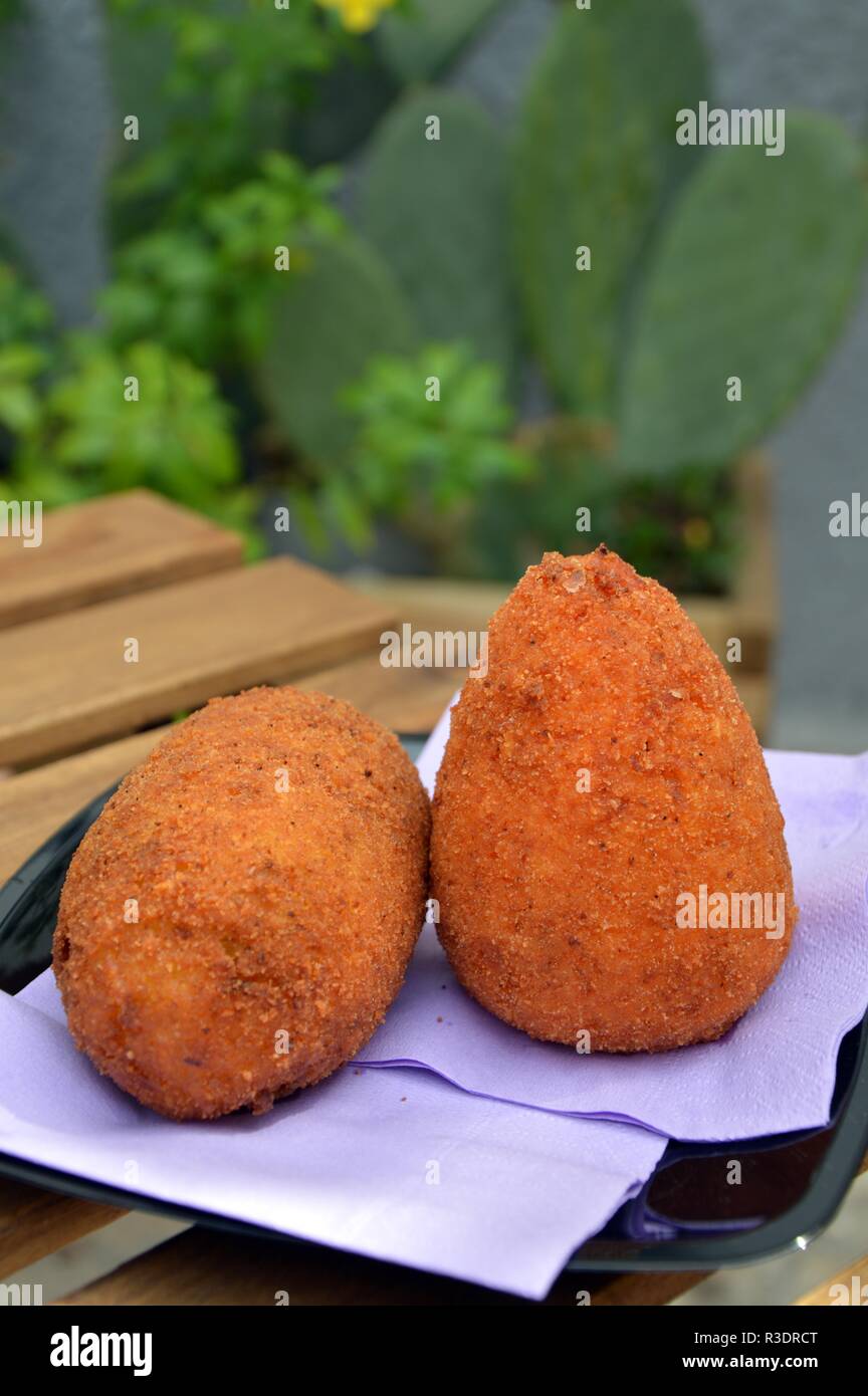Un paio di arancini, tipico siciliano di cibo di strada fatta con riso Foto Stock
