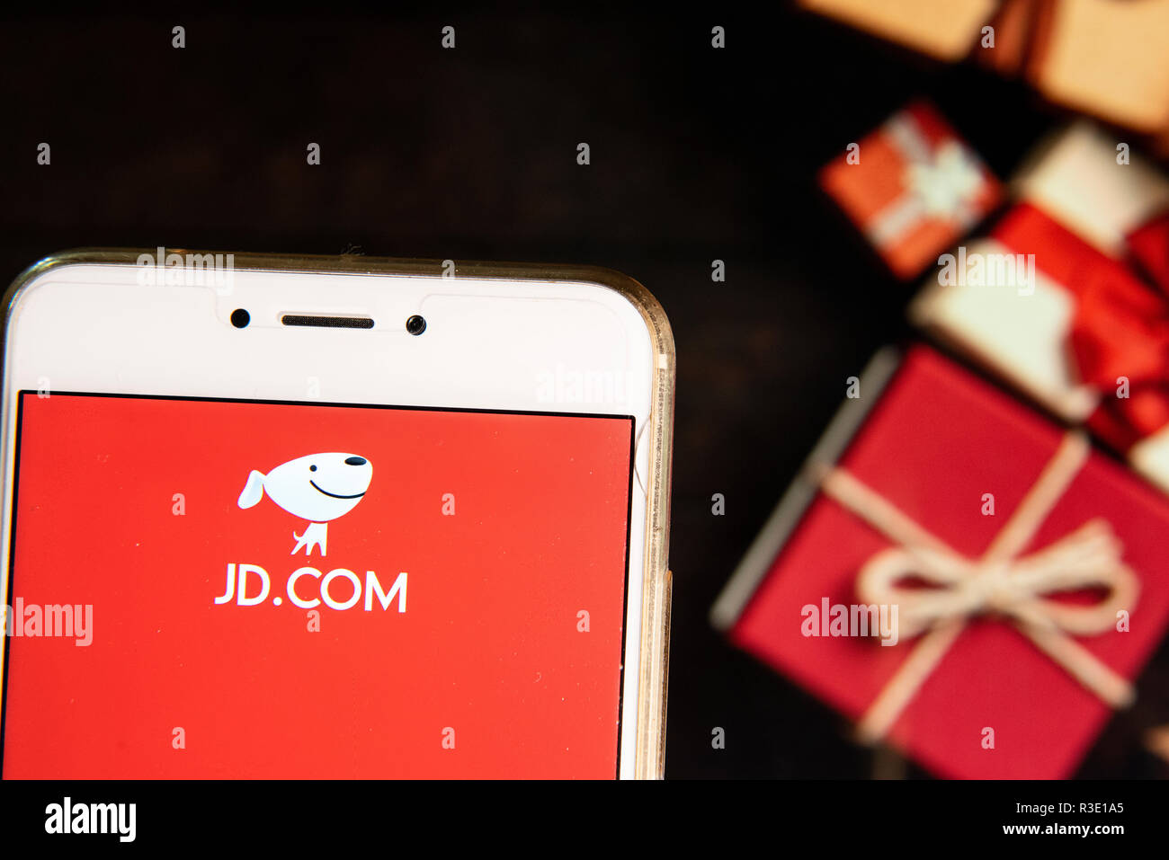 American Chinese azienda di e-commerce JD.com logo è visibile su un androide dispositivo mobile con un Natale regali avvolti in background. Foto Stock