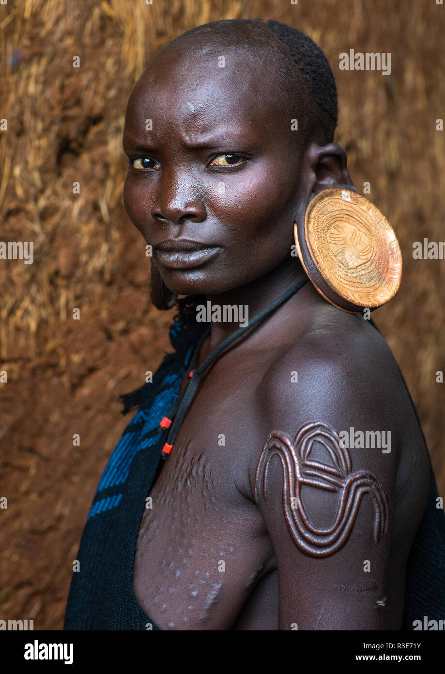 Ritratto di una tribù suri donna con orecchioni allargata ed enormi orecchini, valle dell'Omo, Kibish, Etiopia Foto Stock