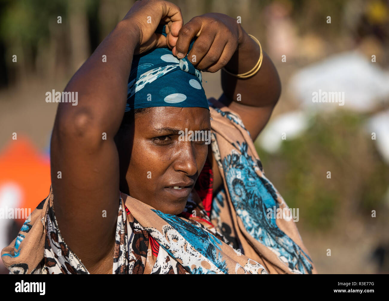 Donna Oromo in un mercato di mettere il suo velo, Amhara Region, Senbete, Etiopia Foto Stock