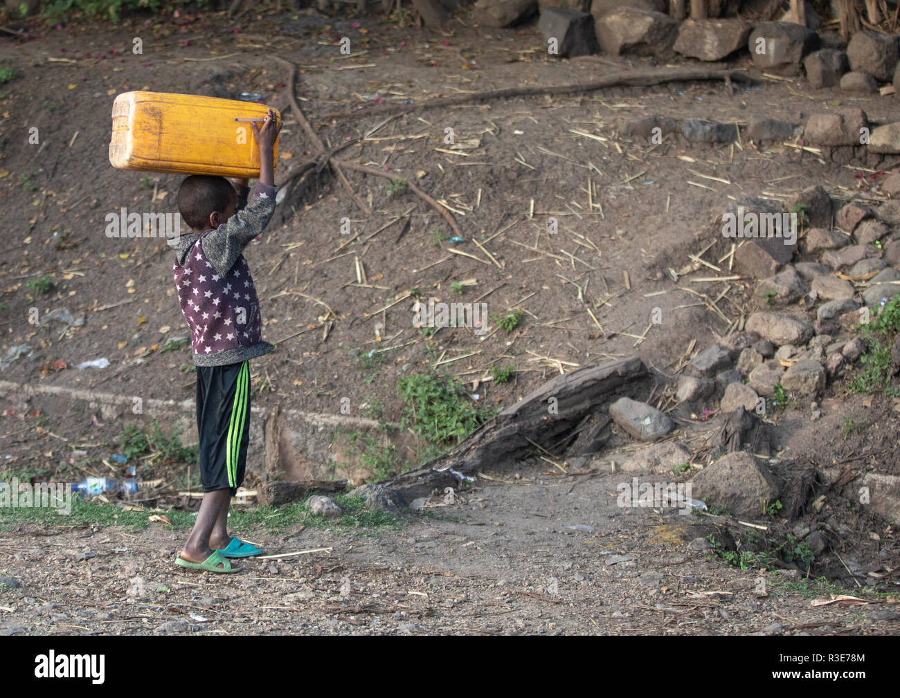 Ragazzo etiope che trasportano taniche di acqua sulla sua testa, Amhara Region, Senbete, Etiopia Foto Stock