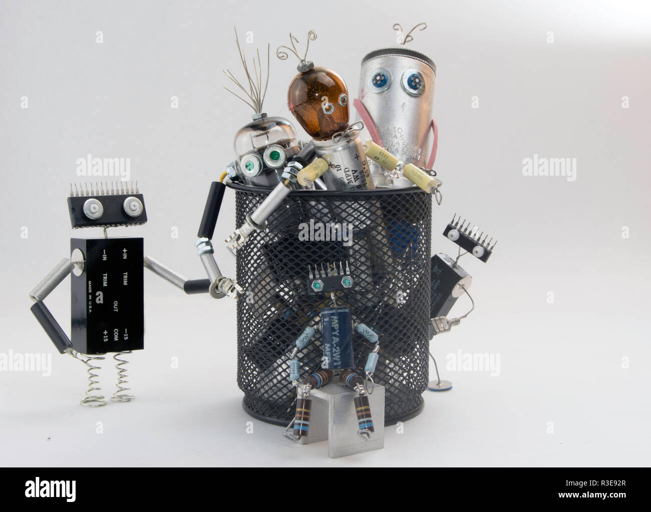 Rifiuti elettronici robot caratteri nel cestino Foto Stock