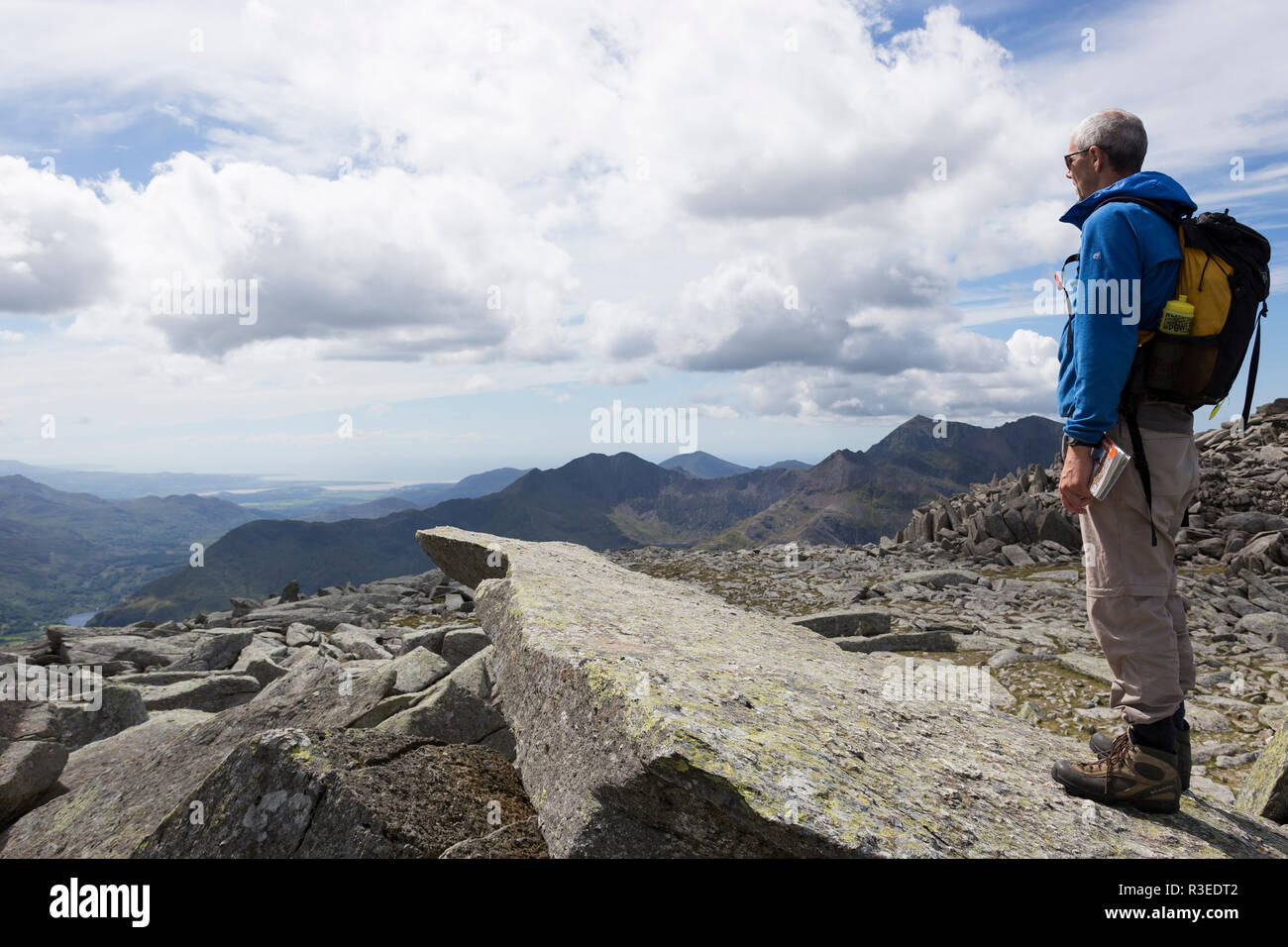 Uomo in piedi sulla Pietra a sbalzo, Glyder Fach, Snowdonia, Wales, Regno Unito Foto Stock