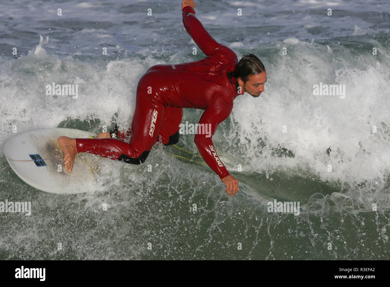 Surf e divertimento con muta rosso Cornovaglia Foto Stock