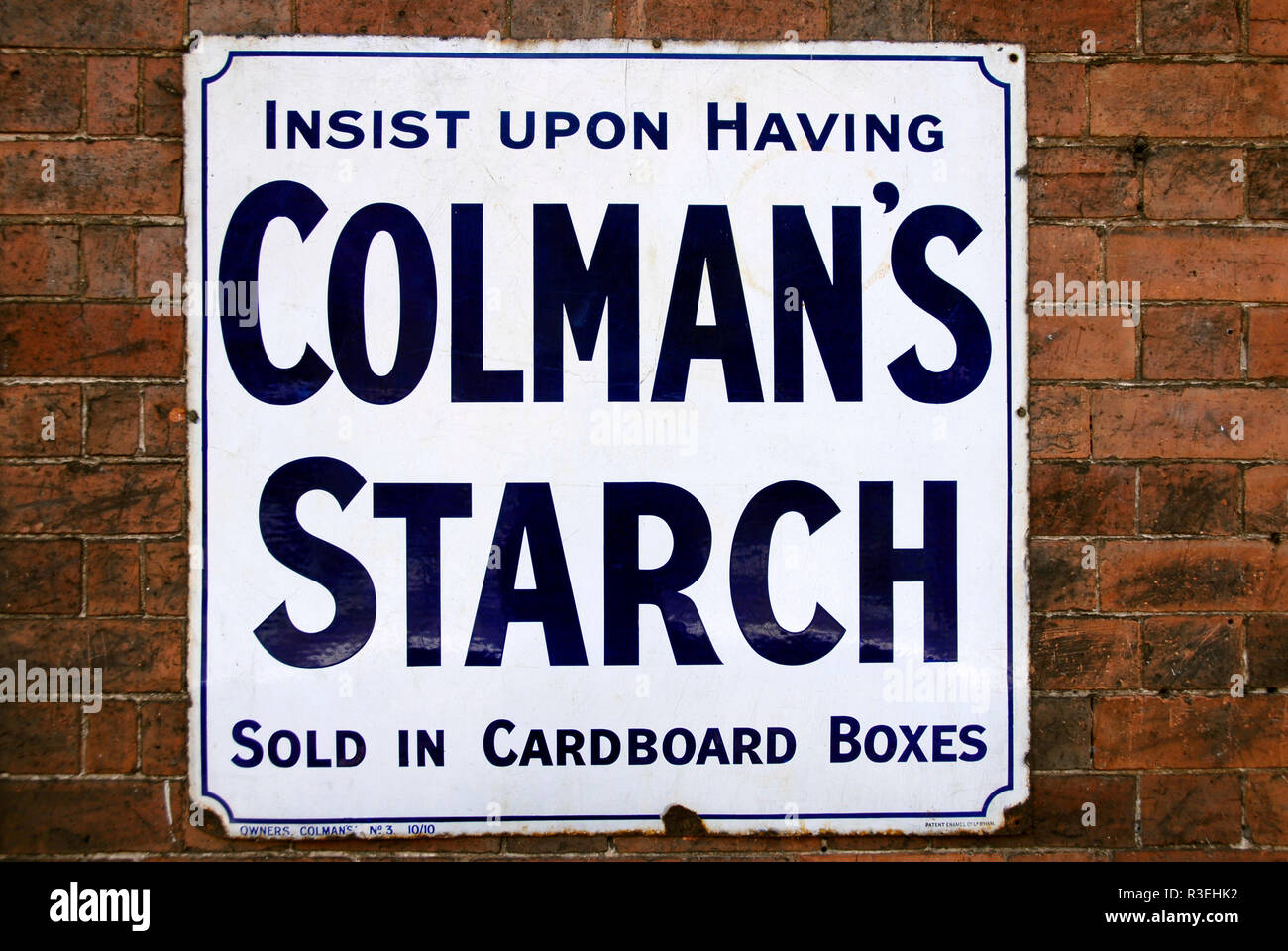 Metallo vecchio pannello pubblicitario per Colman's amido, avvitato ad un muro di mattoni Foto Stock