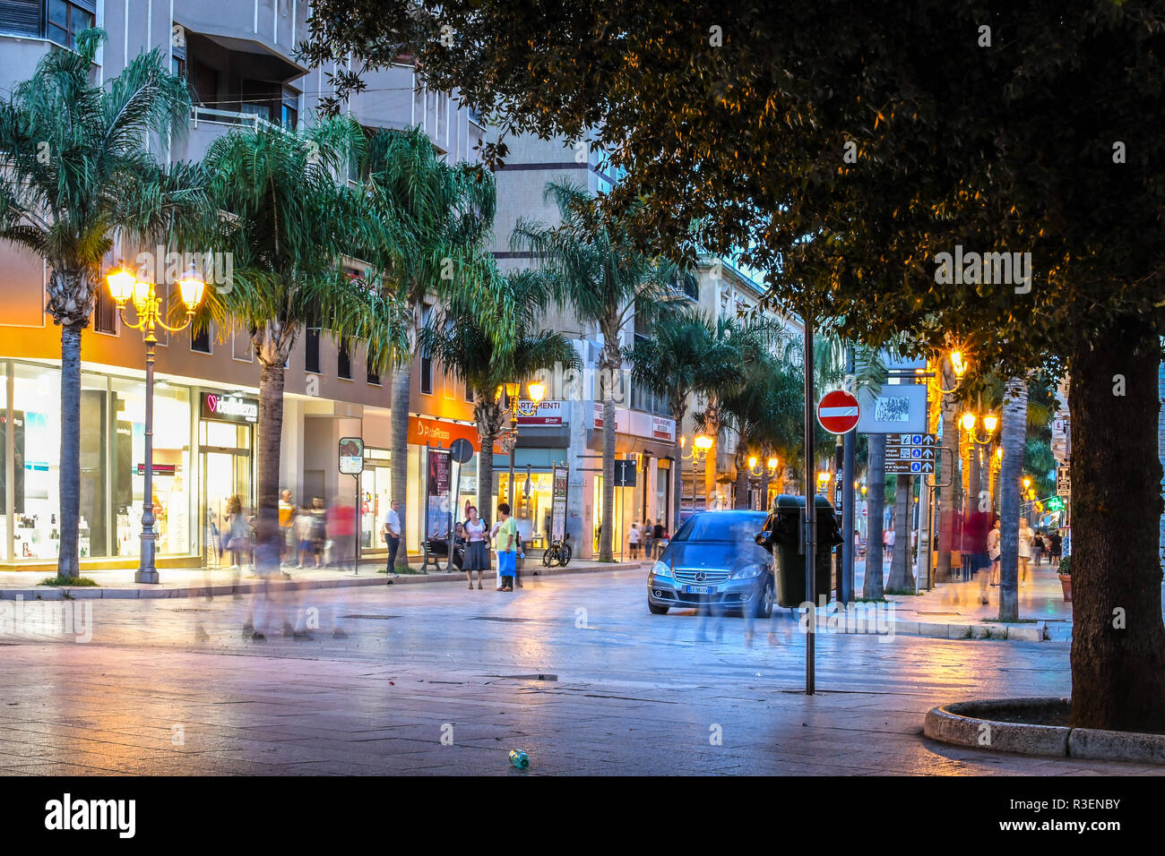 Linea di negozi il principale Corso Umberto con gli abitanti di godersi una serata nella città italiana di Brindisi, nella regione Puglia. Foto Stock