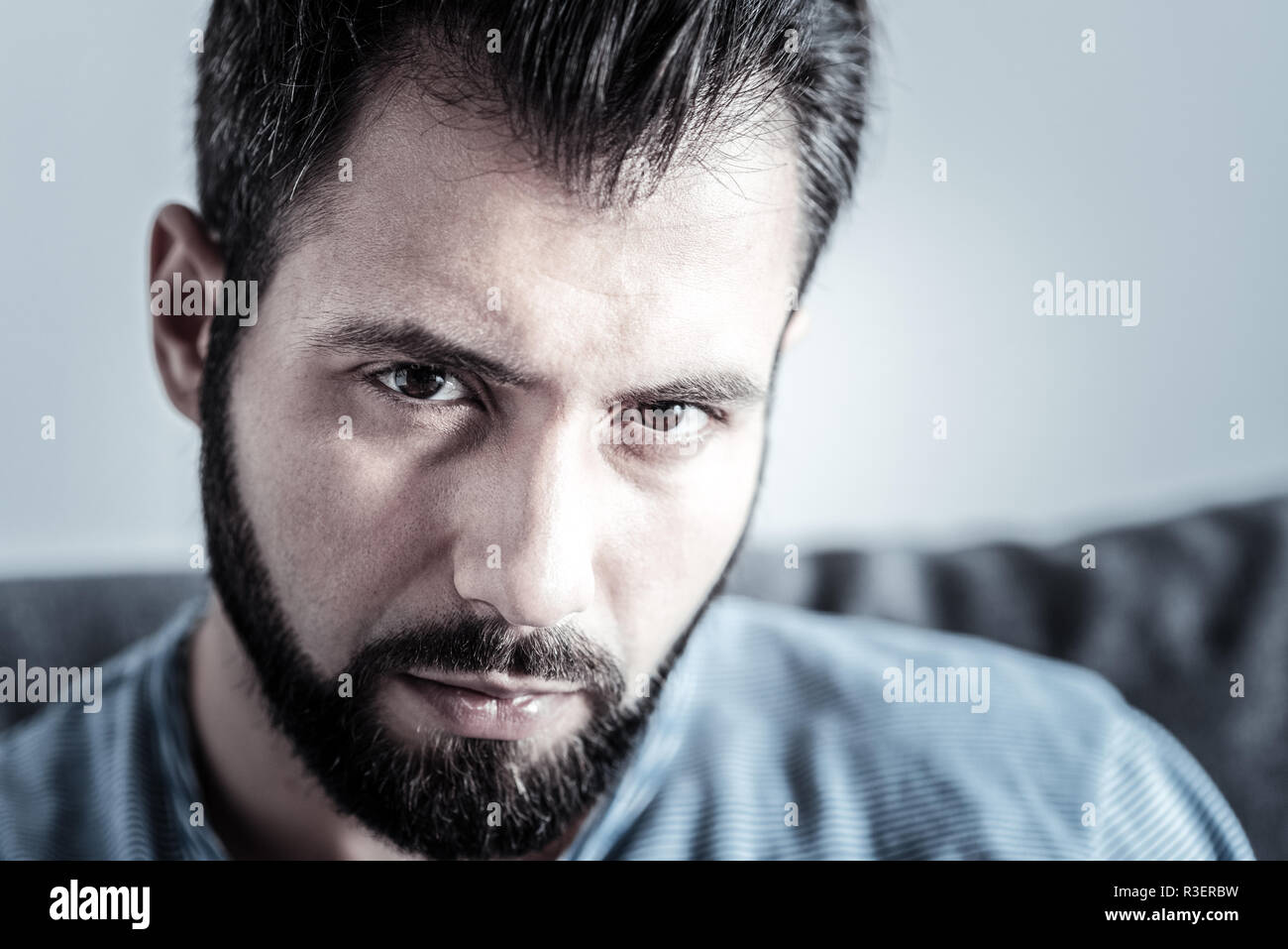 Guardando a voi. Close up uomo gravi che premendo le labbra e piegando la testa mentre la ricerca in avanti Foto Stock