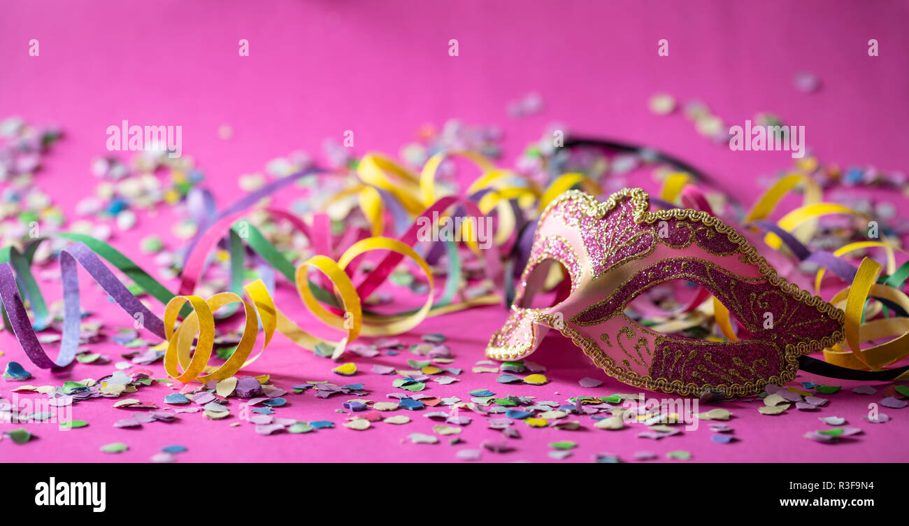 Festa di carnevale. Oro rosa maschera, stelle filanti e coriandoli luminosi  su sfondo rosa, banner Foto stock - Alamy