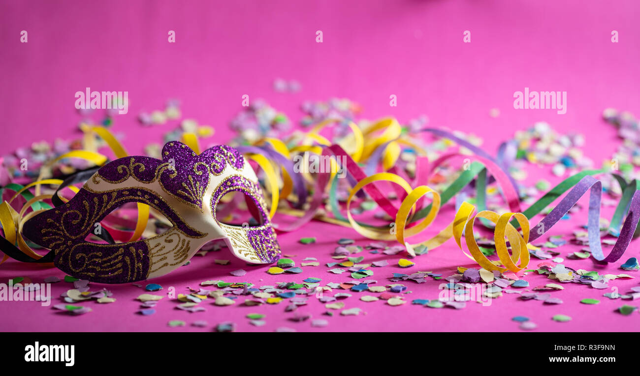 Festa di carnevale. Oro viola maschera, stelle filanti e coriandoli  luminosi su sfondo rosa, banner Foto stock - Alamy