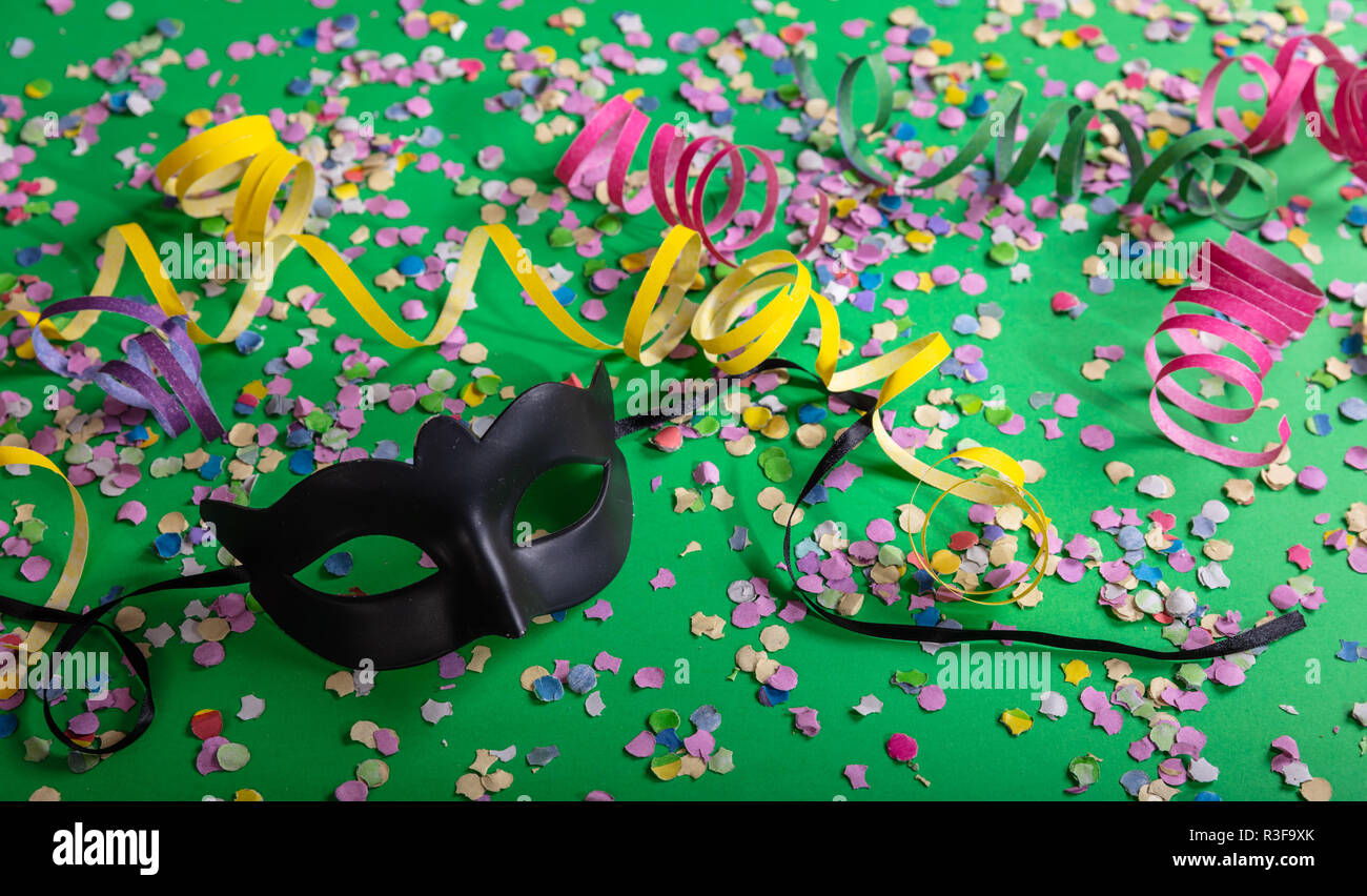Festa di carnevale. Maschera nera, stelle filanti e coriandoli luminosi su  sfondo verde, vista dall'alto Foto stock - Alamy