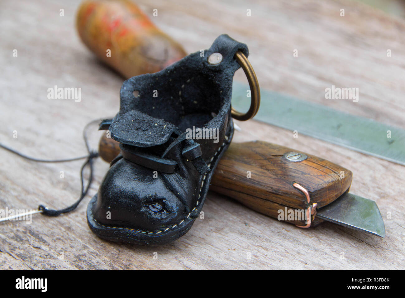 Colorfull portachiavi in pelle a forma di scarpa vecchia su sfondo di legno Foto Stock