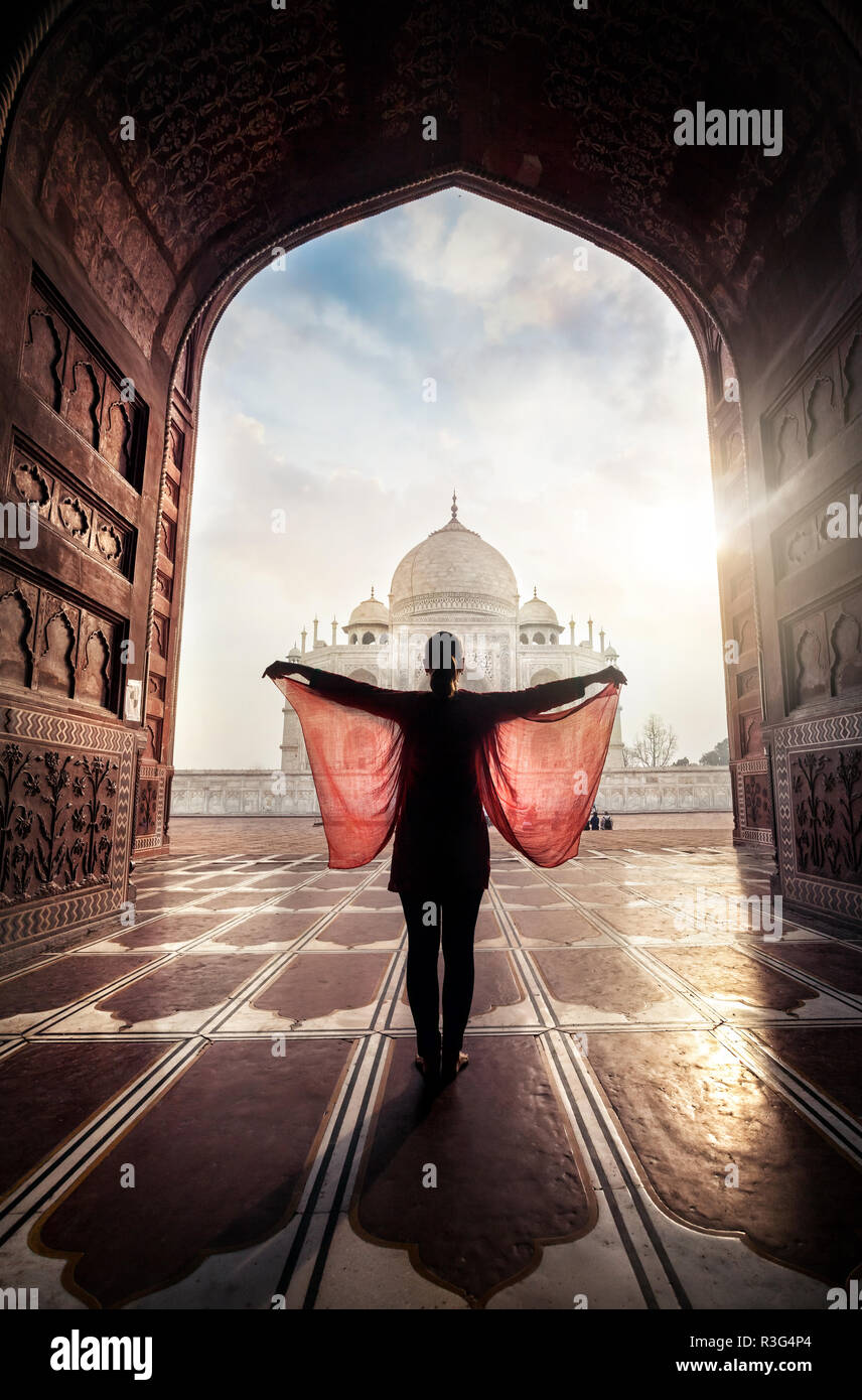 Donna con sciarpa rossa in posa vicino al Taj Mahal di Agra, Uttar Pradesh, India Foto Stock